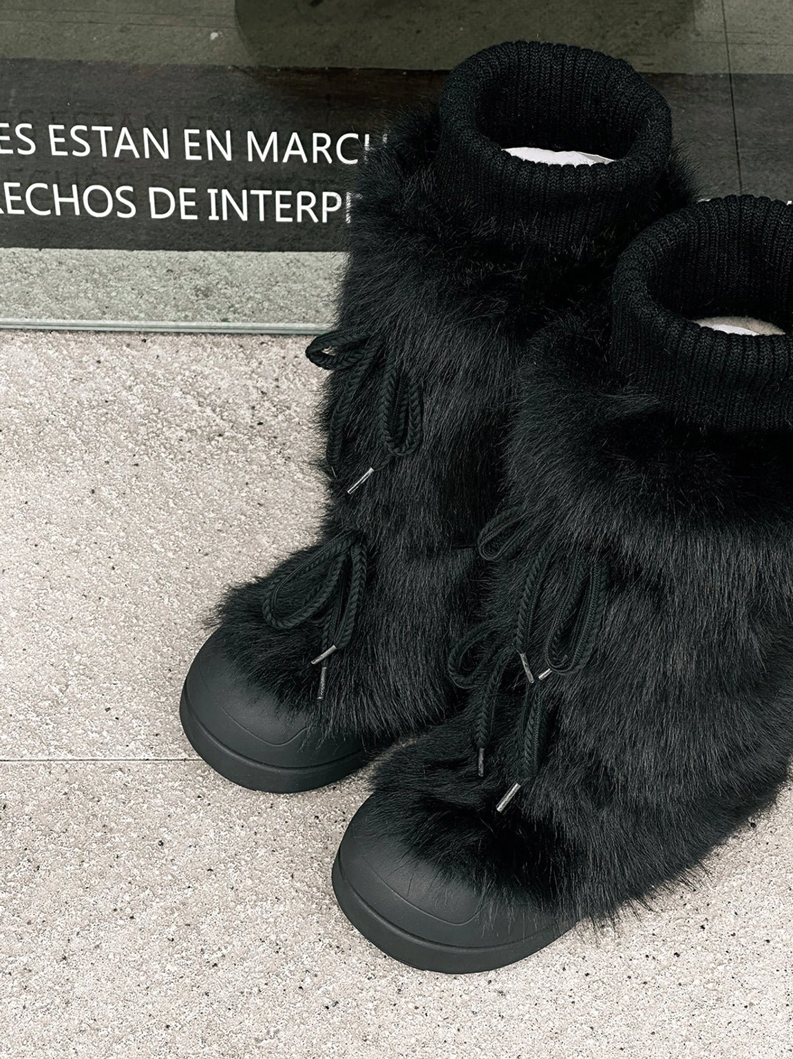 Black and white plush-lined platform boots with bold tall silhouette for women