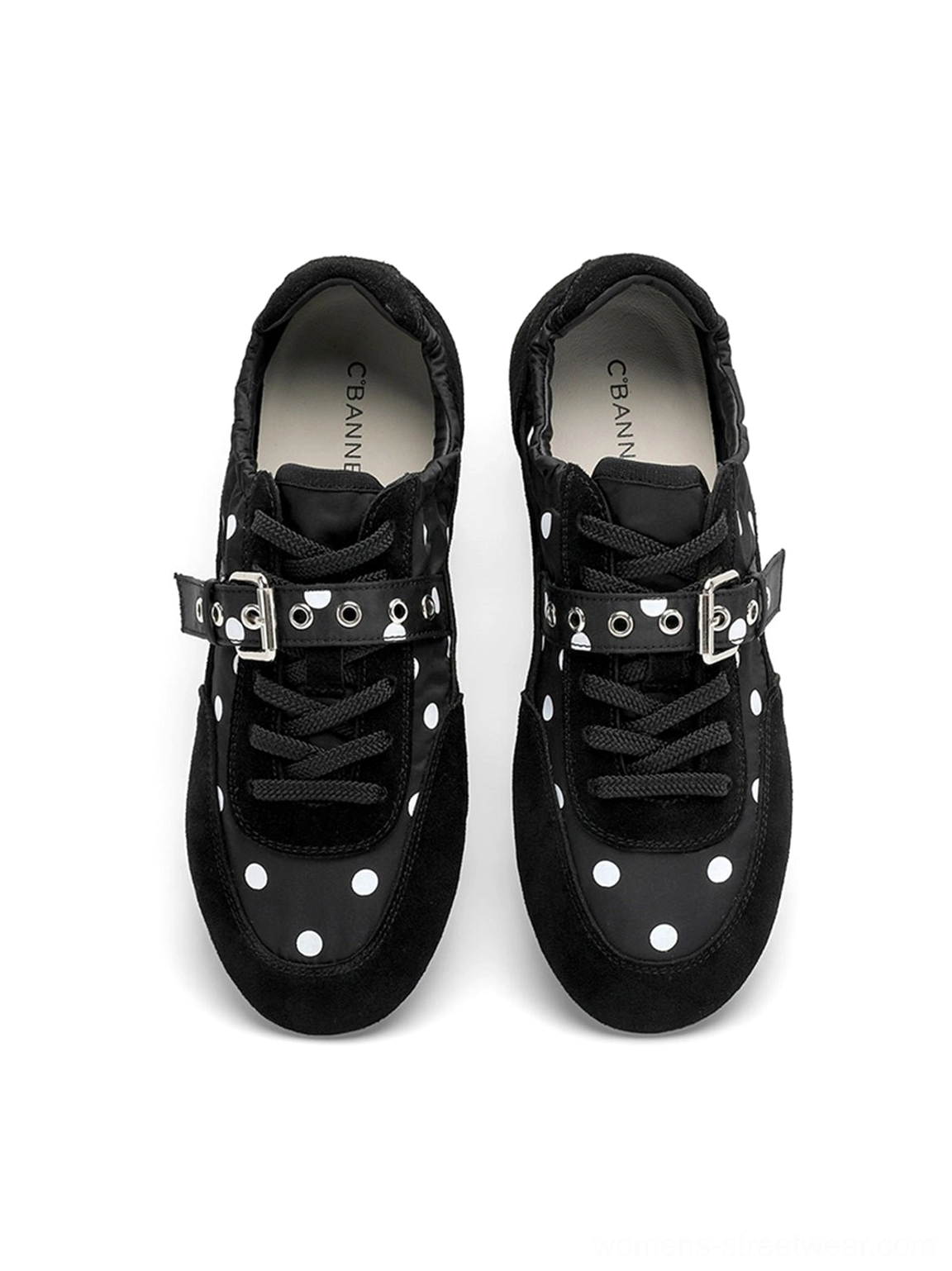 Front view of a pair of black and white polka dot ballet sneakers with matching silver buckle straps and flat soles