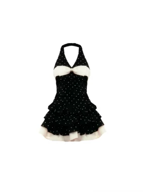 Front flat lay of a black and white polka dot halter swim dress with contrast bow and tiered ruffle skirt