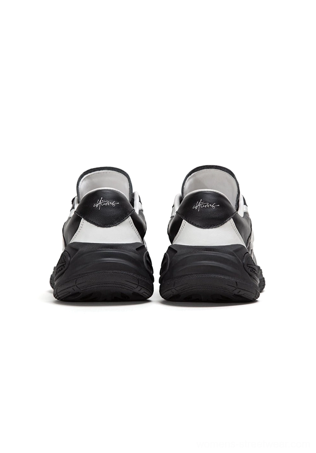 Rear view of black and white quilted streetwear sneakers showing the color-blocked heel and padded lining