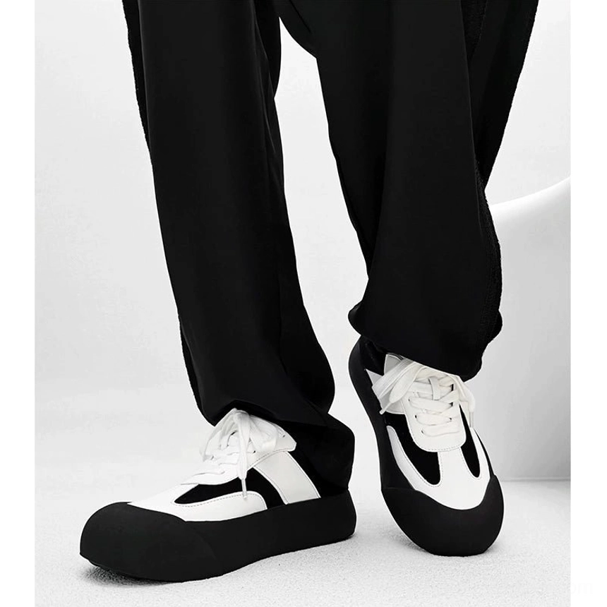 Black and white retro chunky sneakers shown from a low front angle with rounded toe contrast panels and thick platform outsole