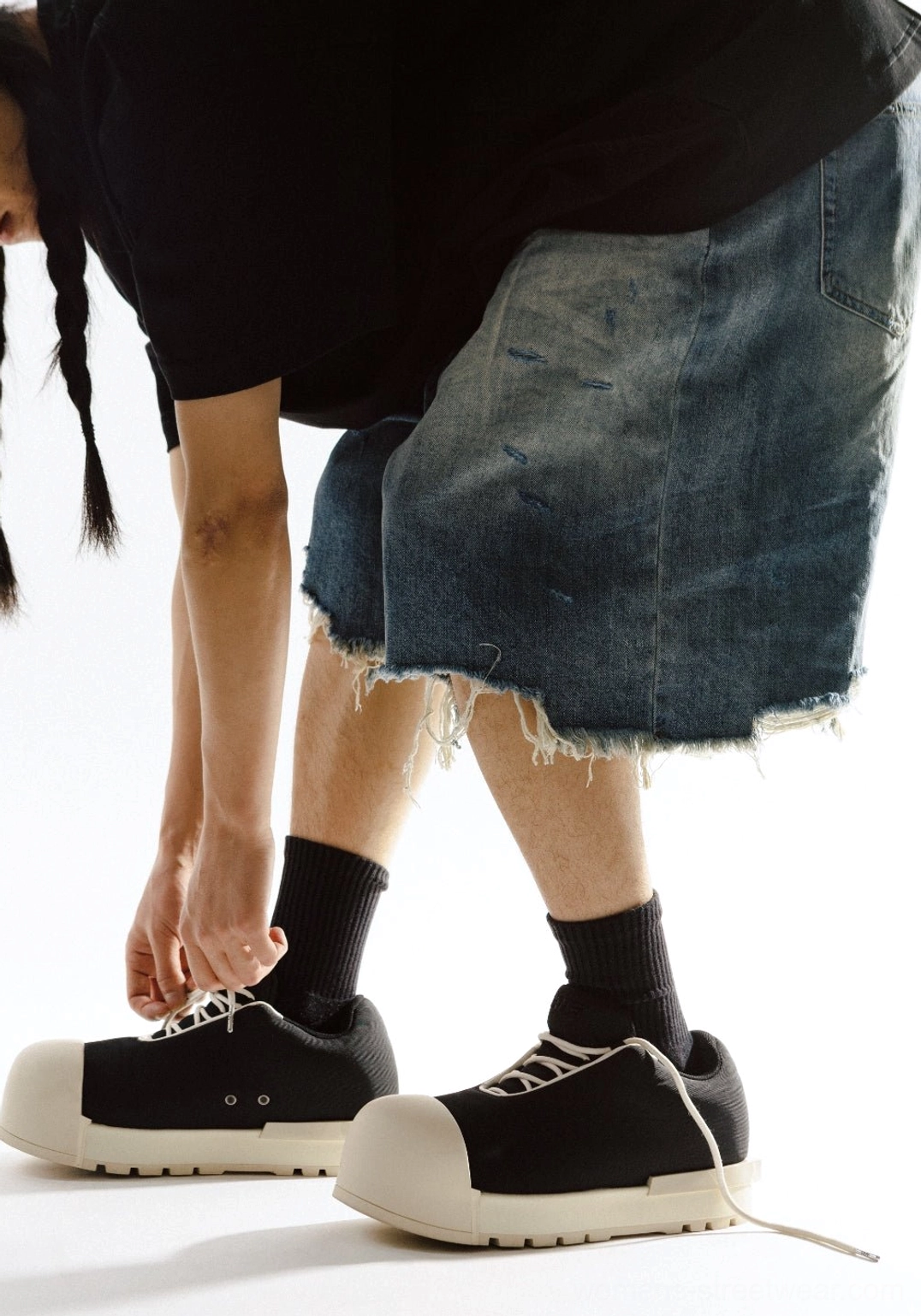 Rear side view of black and white sculpted toe chunky platform low boots with lace-up closure and padded collar