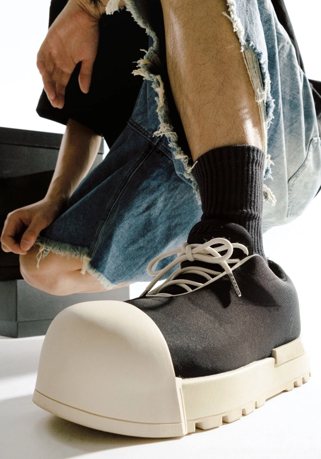 Close-up of black and white sculpted toe chunky platform low boots showing oversized toe cap thick sole and laces