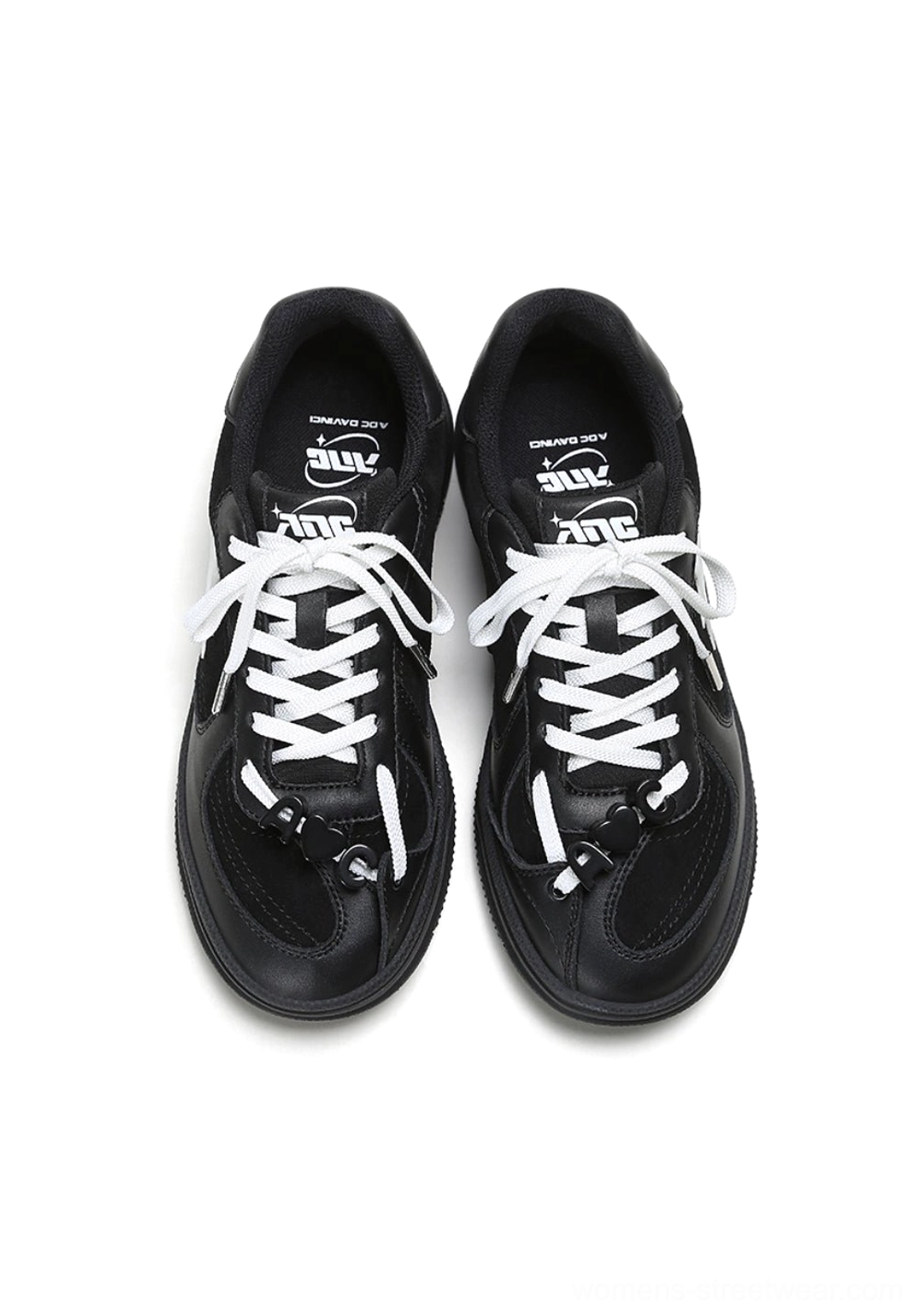 Top view of black and white solar star applique court sneakers showing white laces, contrasting panels, and insoles