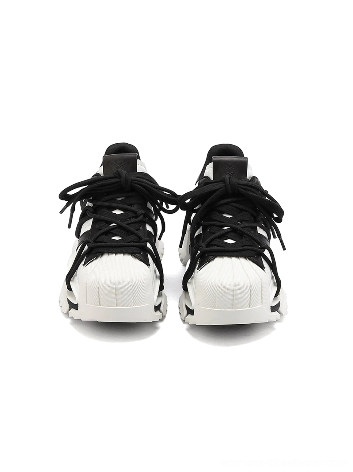 Close front view of black and white streetwear chunky sneakers with rounded toe, classic lace-up construction, and high-contrast sculpted sole