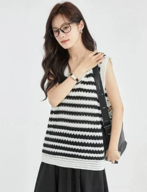 Close front view of a black and white striped crochet sleeveless knit top featuring a wide relaxed cut, textured weave, and contrasting neckline trim