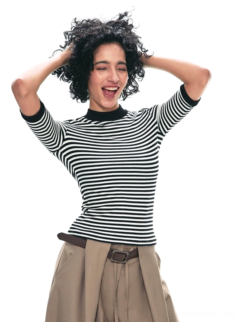 Black and white striped mock neck half-sleeve streetwear top styled with khaki wide-leg pants