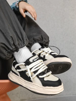 Black and white chunky platform sneakers worn with cropped cargo pants and white crew socks in a top-down Y2K streetwear outfit view