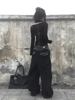 Back view of black wide leg baggy jeans with leopard print back pocket details and oversized streetwear silhouette