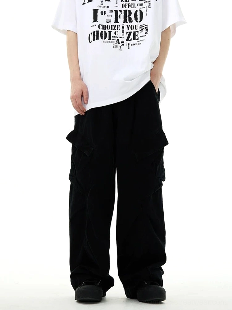 Black wide-leg cargo workwear pants on a male model with an oversized graphic tee, featuring a relaxed baggy fit, heavy utility styling, and large side pockets