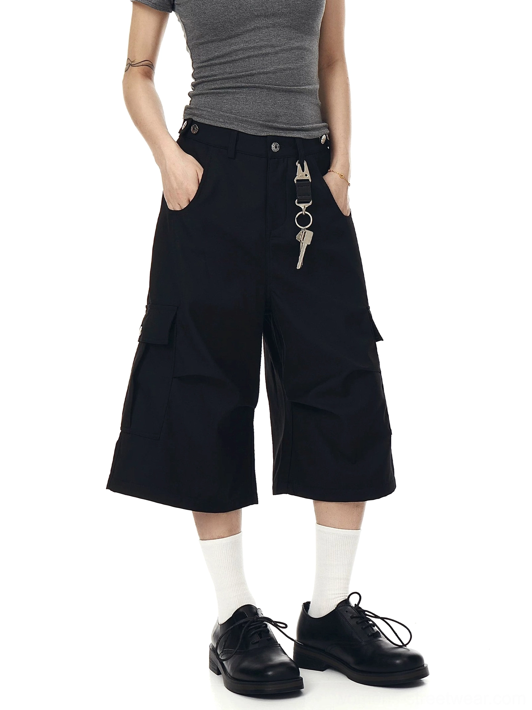 Black wide-leg cropped cargo shorts styled with a black cropped top, leather shoes, belt loops, and utility pocket details