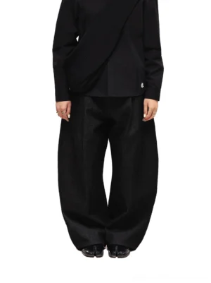 Back full-body styling view of black wide-leg denim jeans worn with an all-black top and polished leather shoes