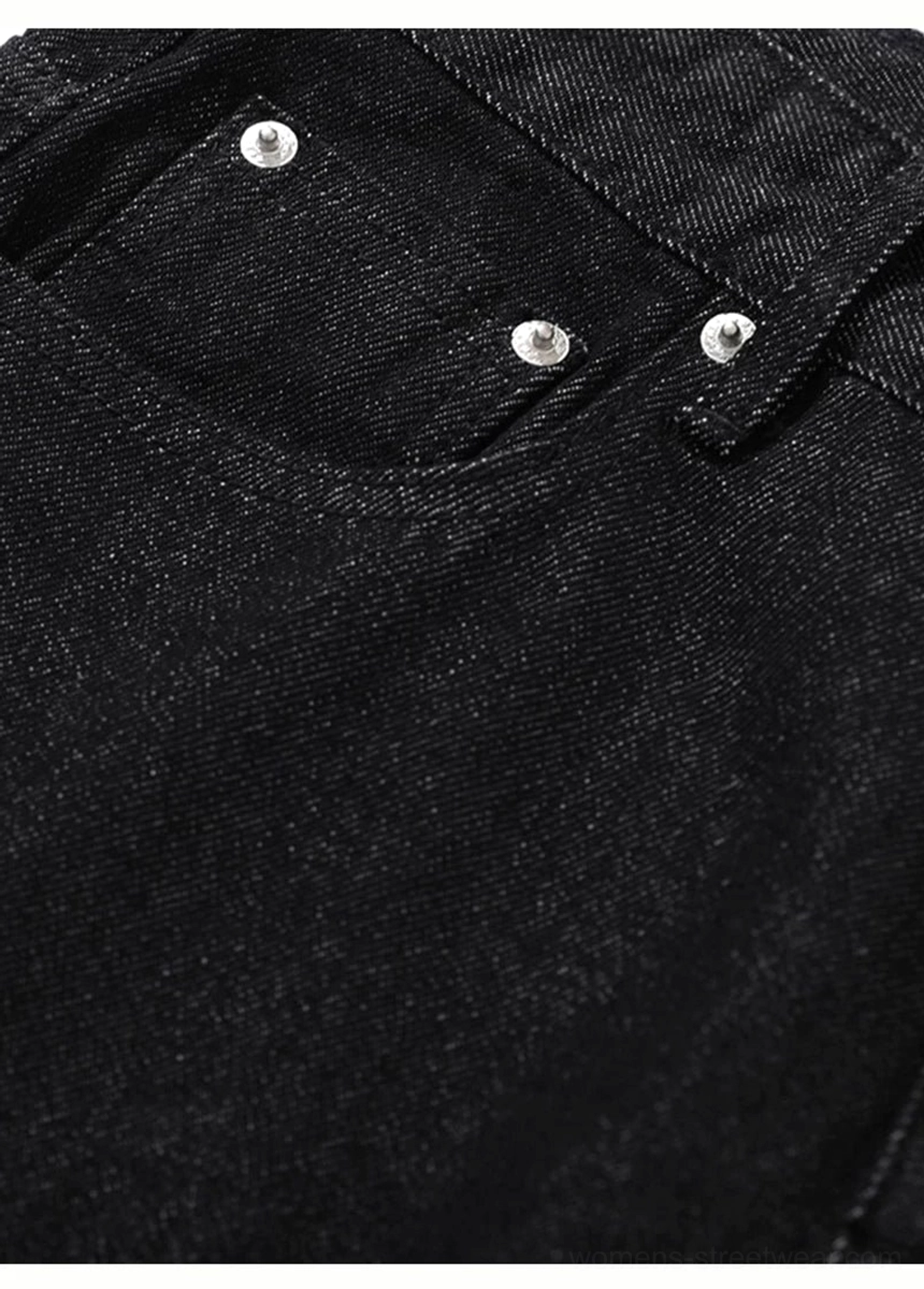 Close-up side view of black wide leg jeans back pocket with silver rivet detailing
