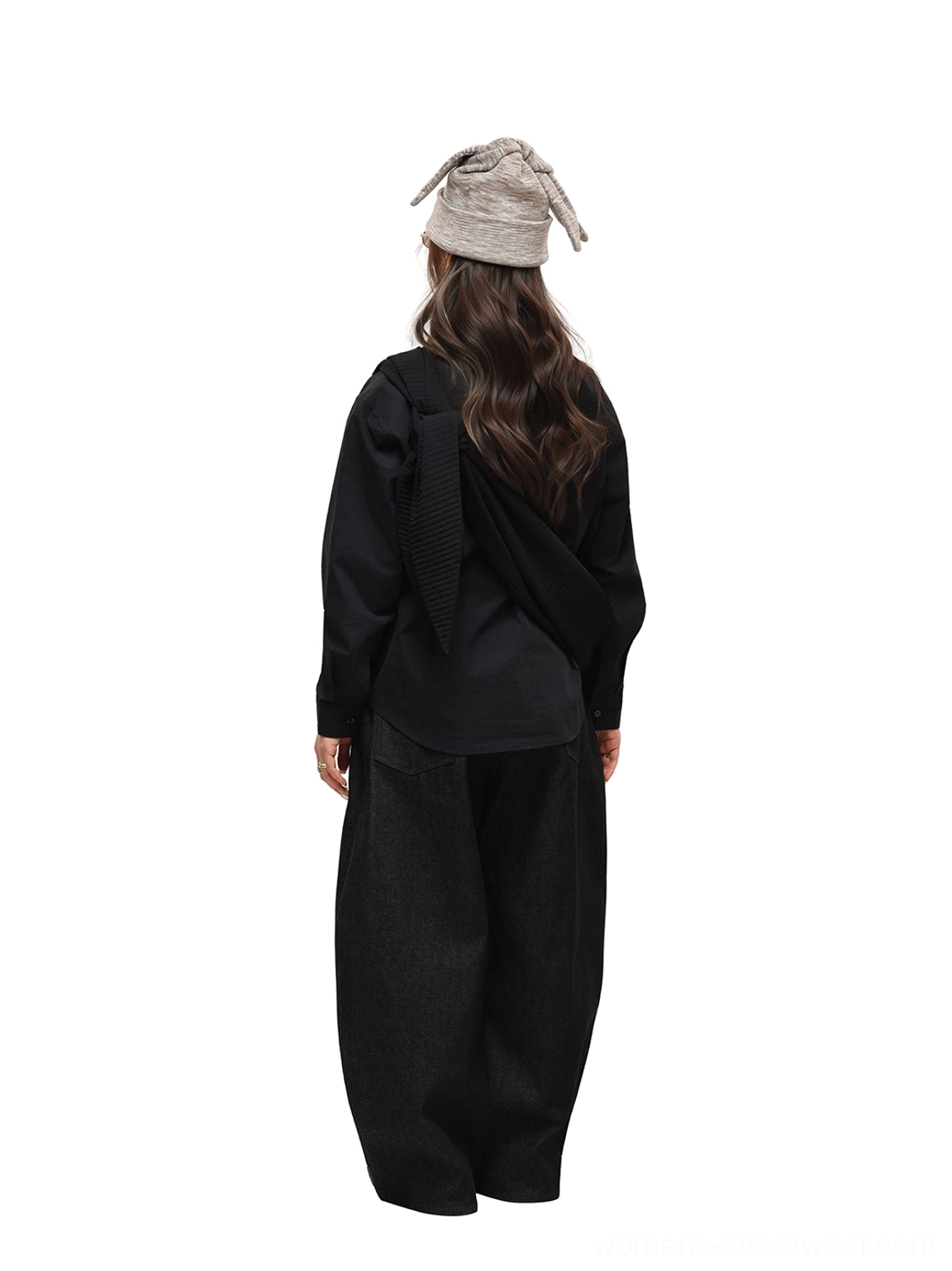 Back view of black wide-leg jeans styled with a grey bucket hat and monochrome outfit, showing relaxed drape over the shoes