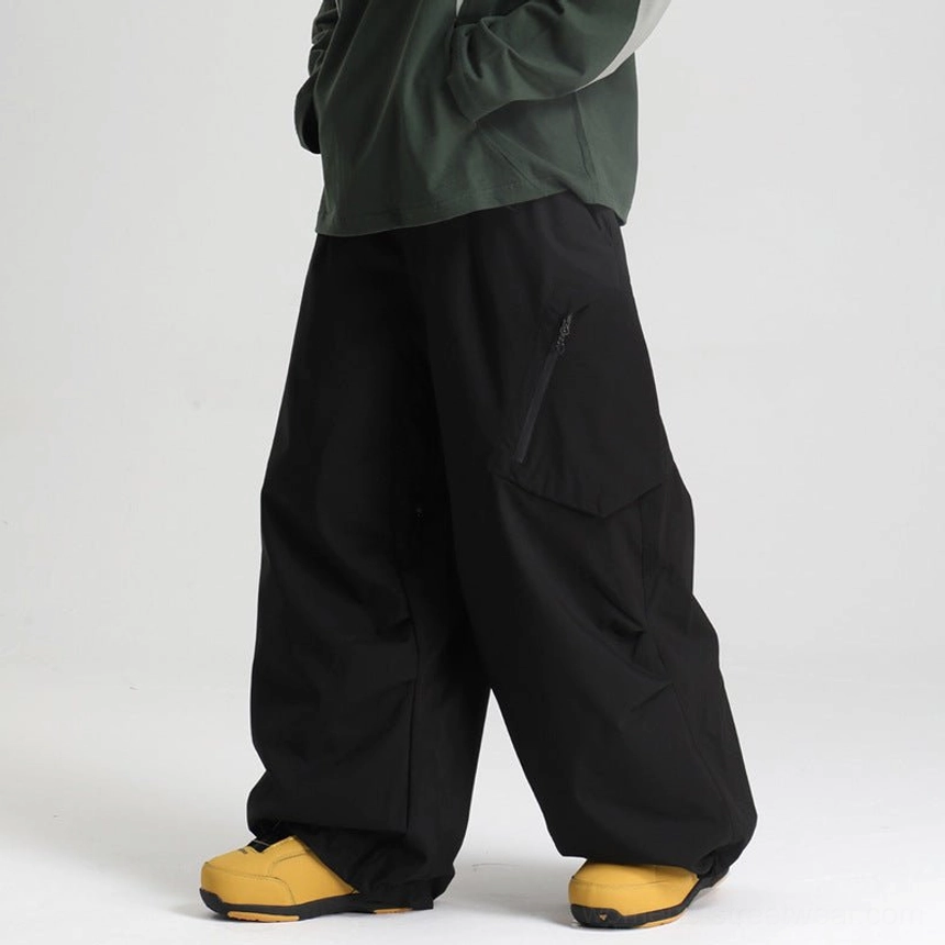 Black oversized snow pants low side view male model dark green top hidden cargo pocket loose wide leg