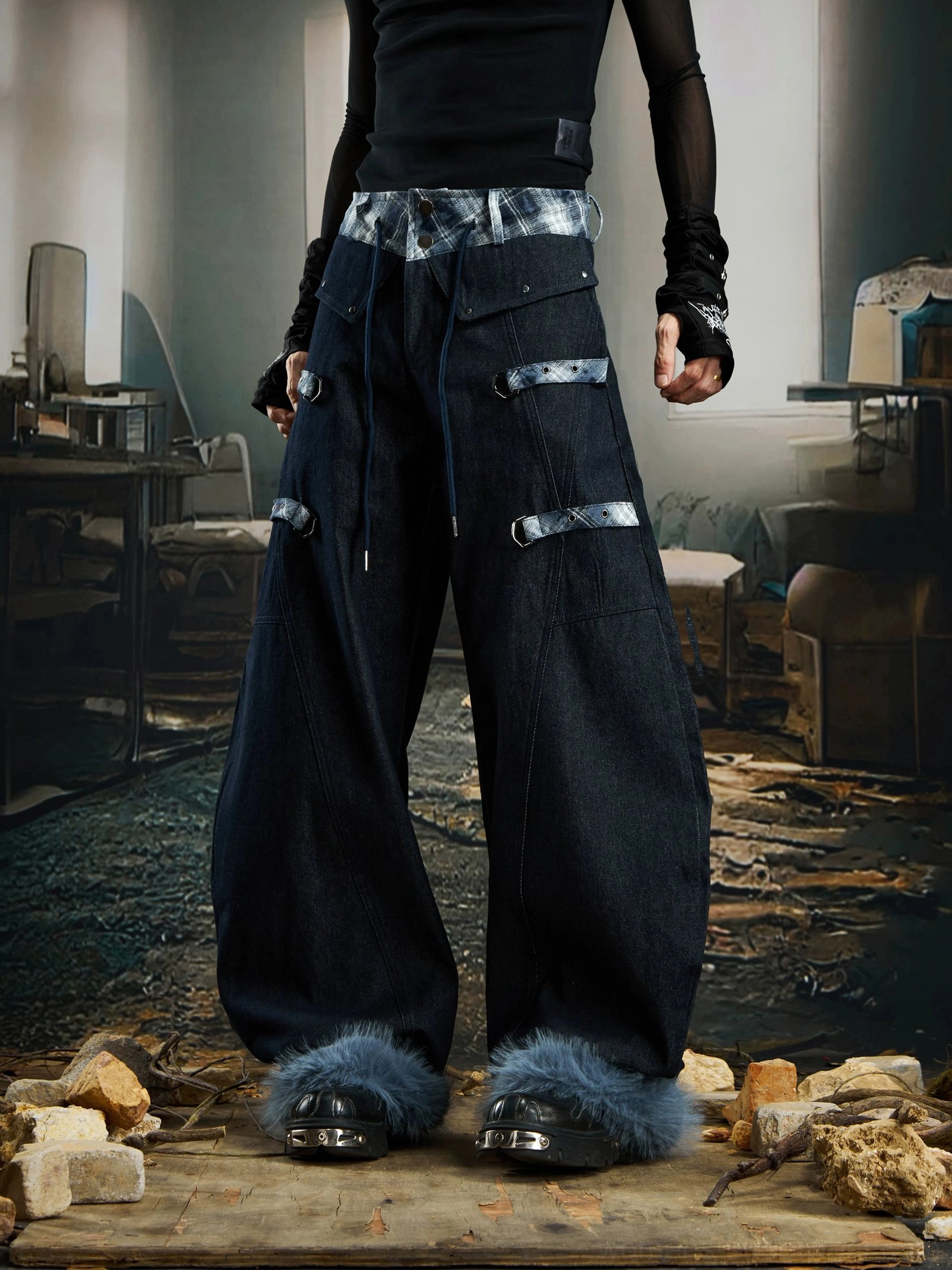 Low-angle view of black wide-leg streetwear cargo pants with blue-grey plaid trim decorative canvas straps and light blue fur cuffs