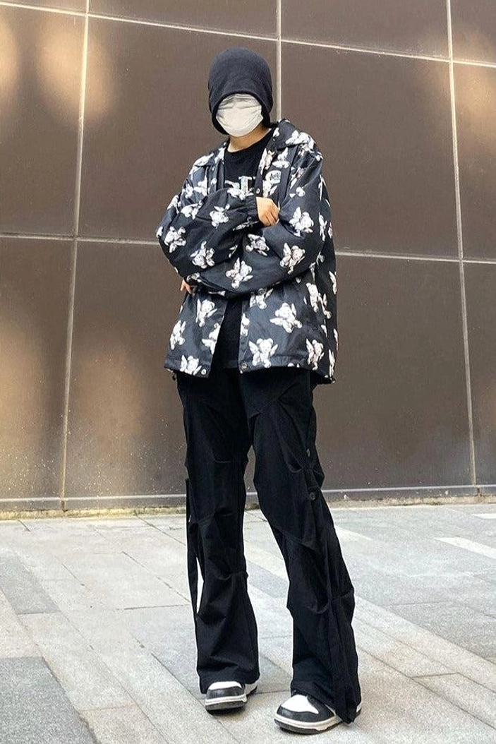 Black wide-leg streetwear cargo pants styled with a patterned jacket knit beanie face mask and low-top sneakers outdoors