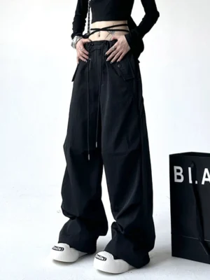 Black wide-leg streetwear cargo pants styled with a cropped black top and chunky platform sneakers for a bold Y2K urban outfit