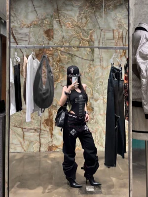 Black wide-leg streetwear jeans with graphic pocket embroidery and red stitching shown in a full outfit mirror styling