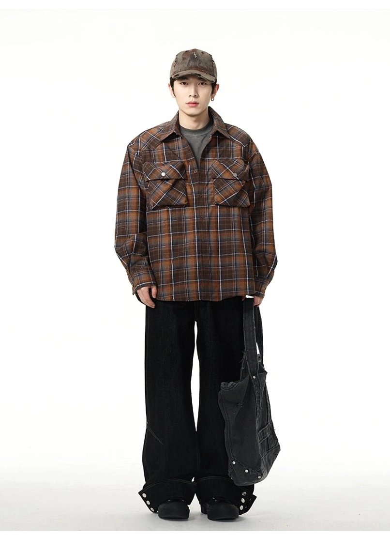 Full front view of black wide-leg streetwear jeans styled with a brown plaid shirt, cap, and canvas tote bag