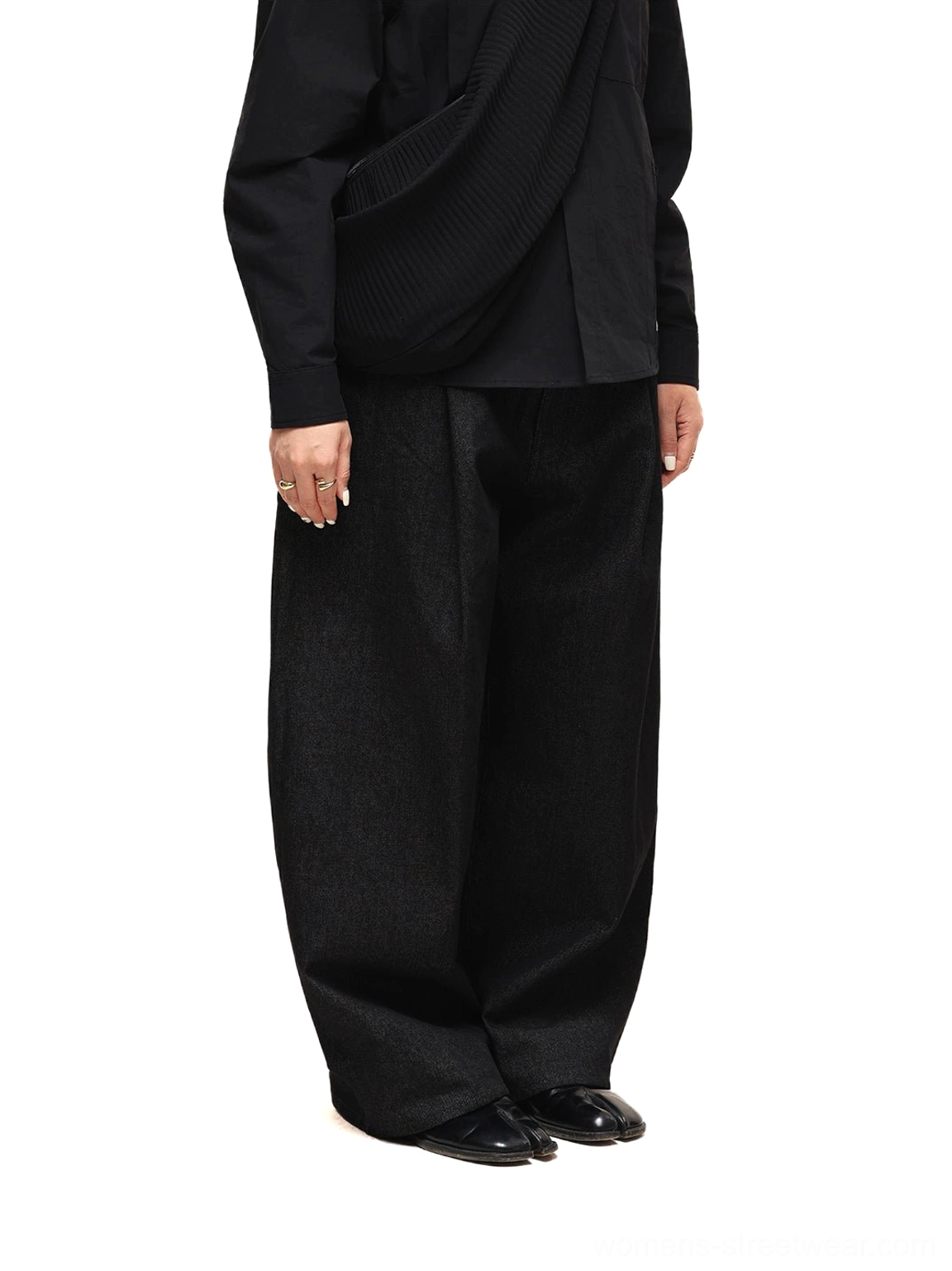 Side silhouette of black wide-leg streetwear jeans showing the tailored waist, substantial denim drape, and oversized leg shape