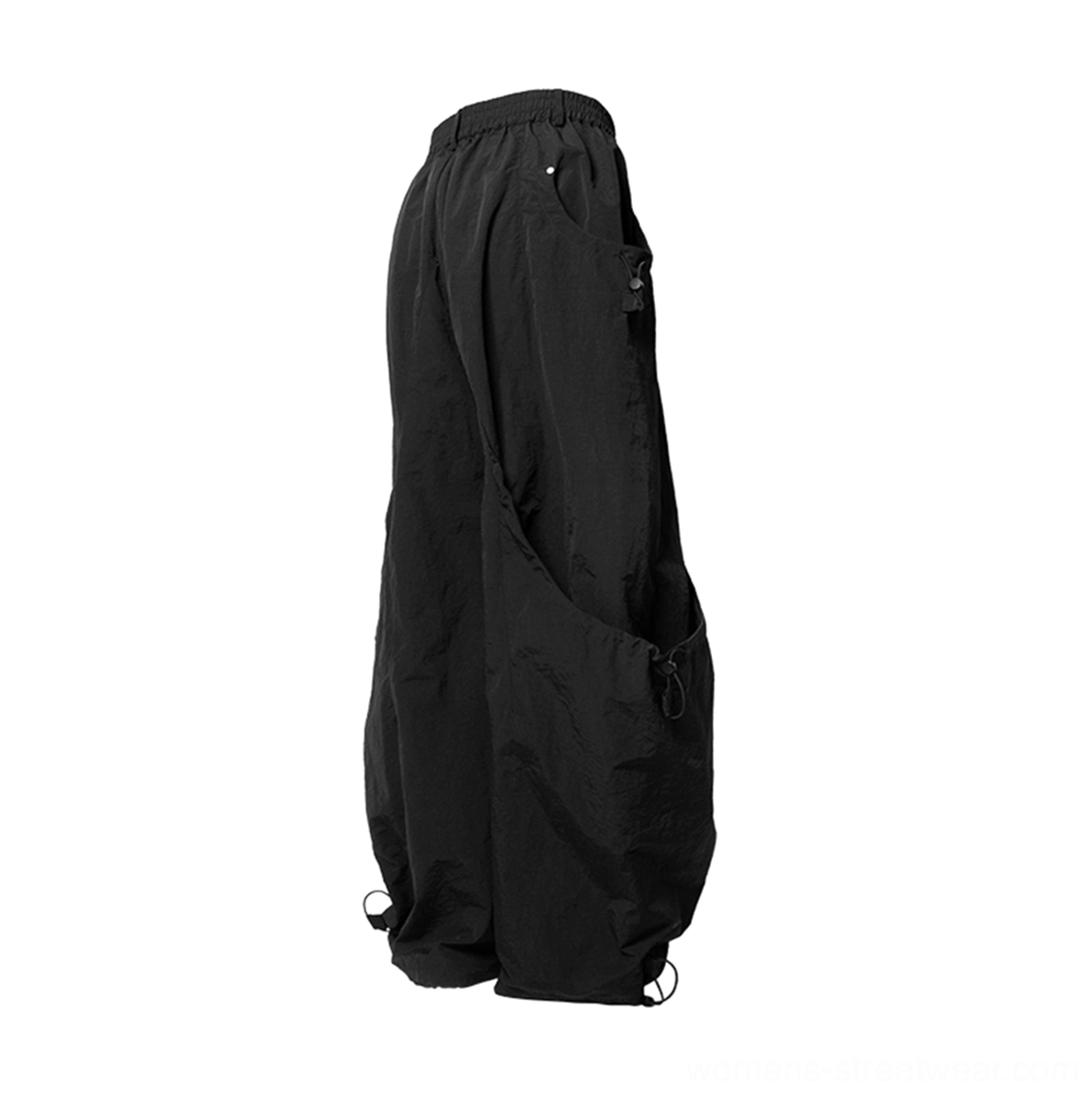 Side profile of black relaxed wide leg technical cargo pants with a high rise waist and utility streetwear silhouette