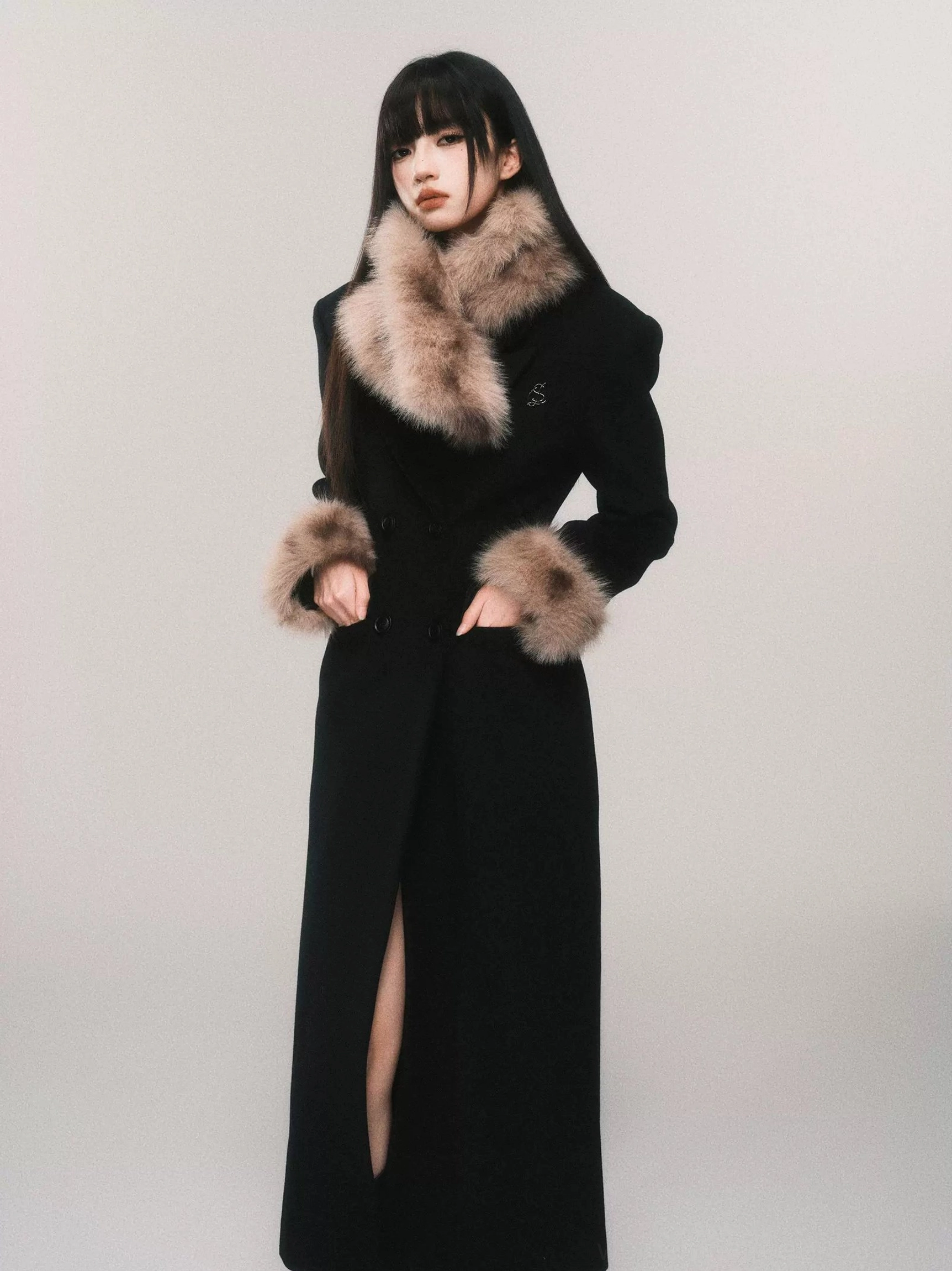 Black women's double-breasted faux fur cuff wool blend maxi coat shown in a front three-quarter studio view with notch lapels