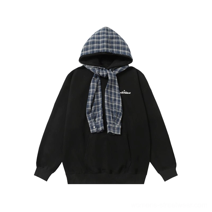 Flat lay view of a black oversized plaid accent hoodie with blue plaid hood lining, subtle chest text, kangaroo pocket, and relaxed women’s streetwear fit