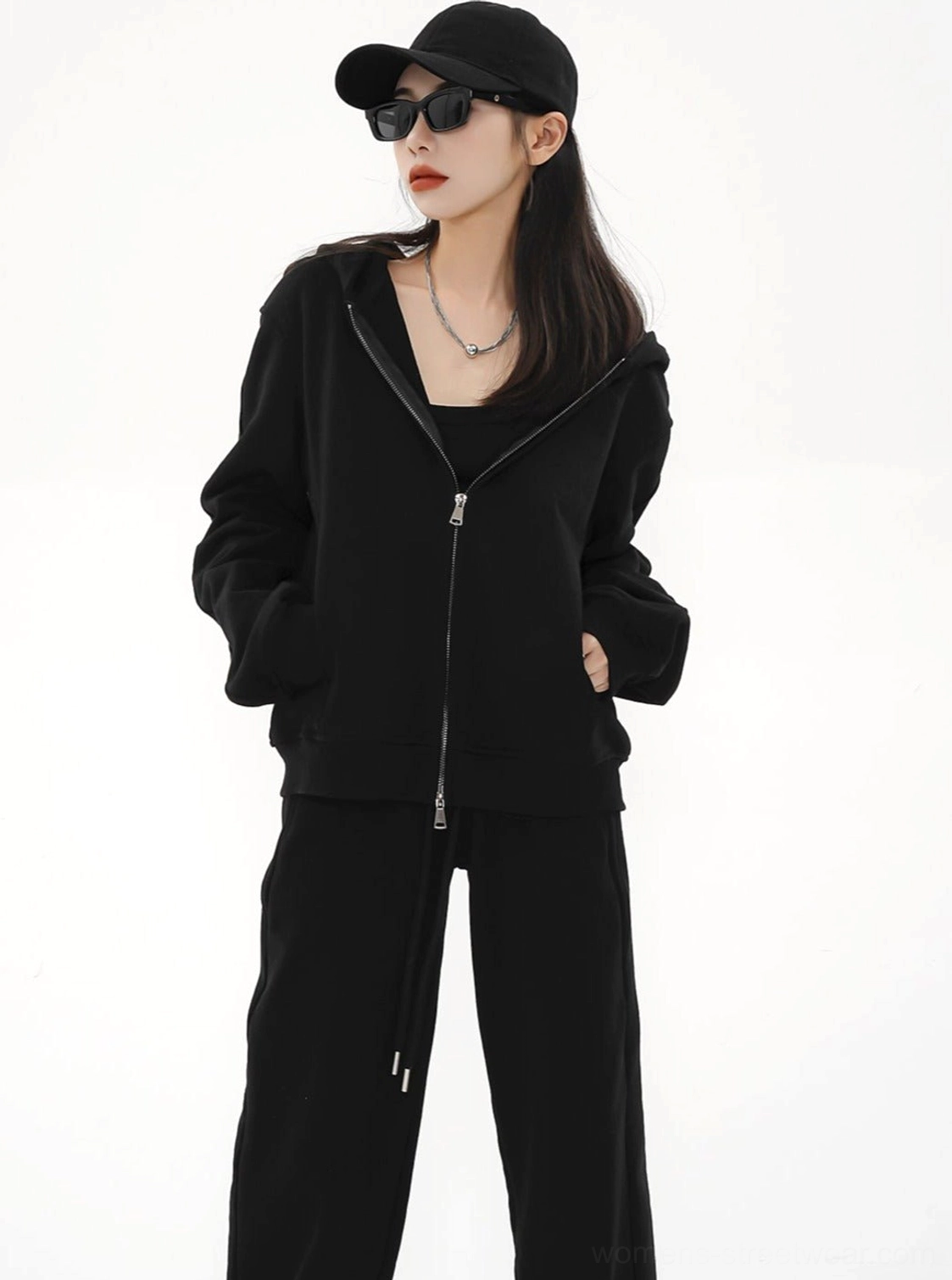 Women's black zip-up hoodie jacket shown from a three-quarter angle with relaxed fit and urban streetwear styling