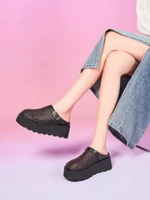 Model wearing black woven cutout platform mules with chunky platform sole and silver buckle styled with a denim midi skirt