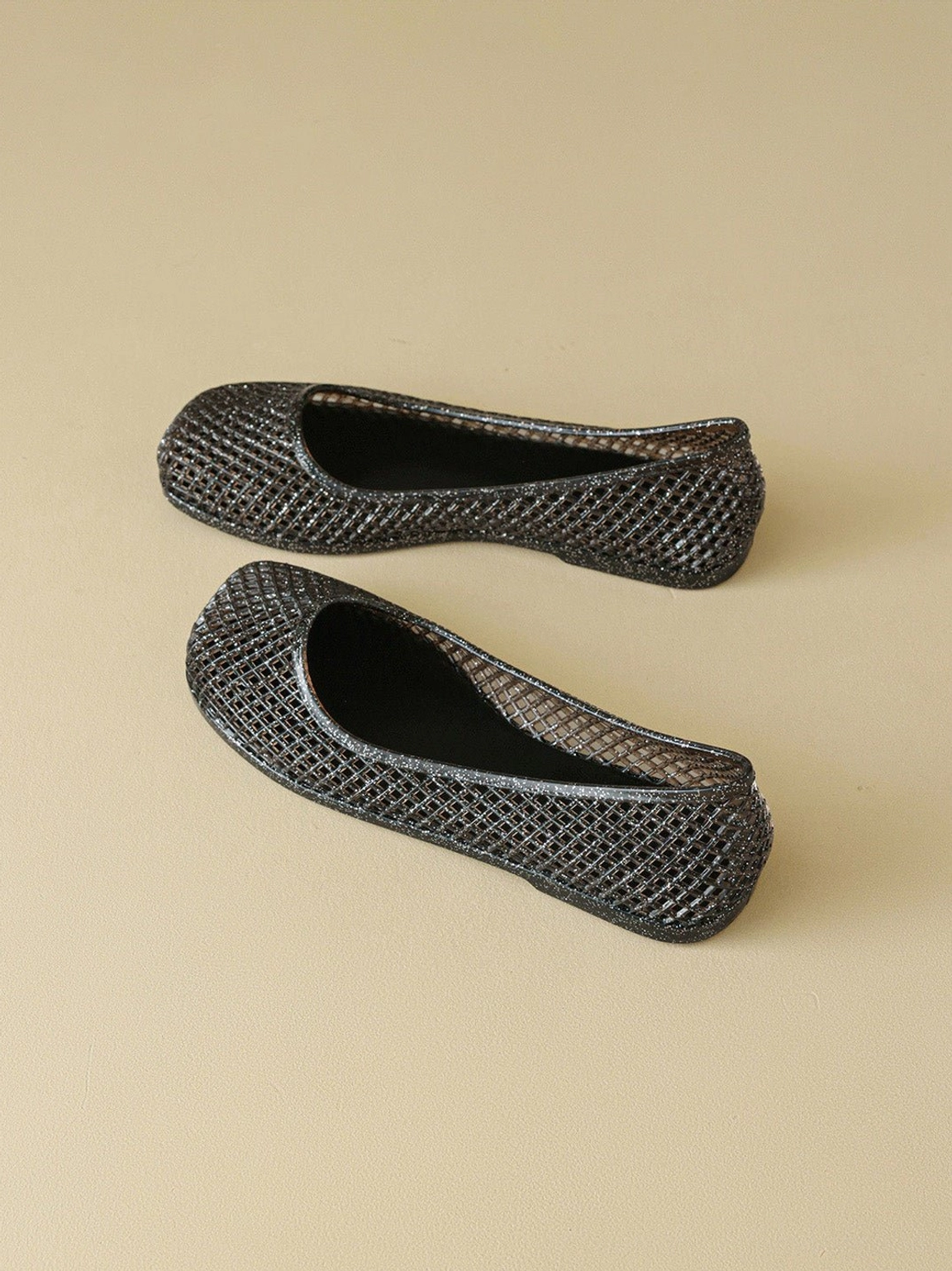 Top-down display of black woven mesh jelly ballet flats showing the flexible low-profile design