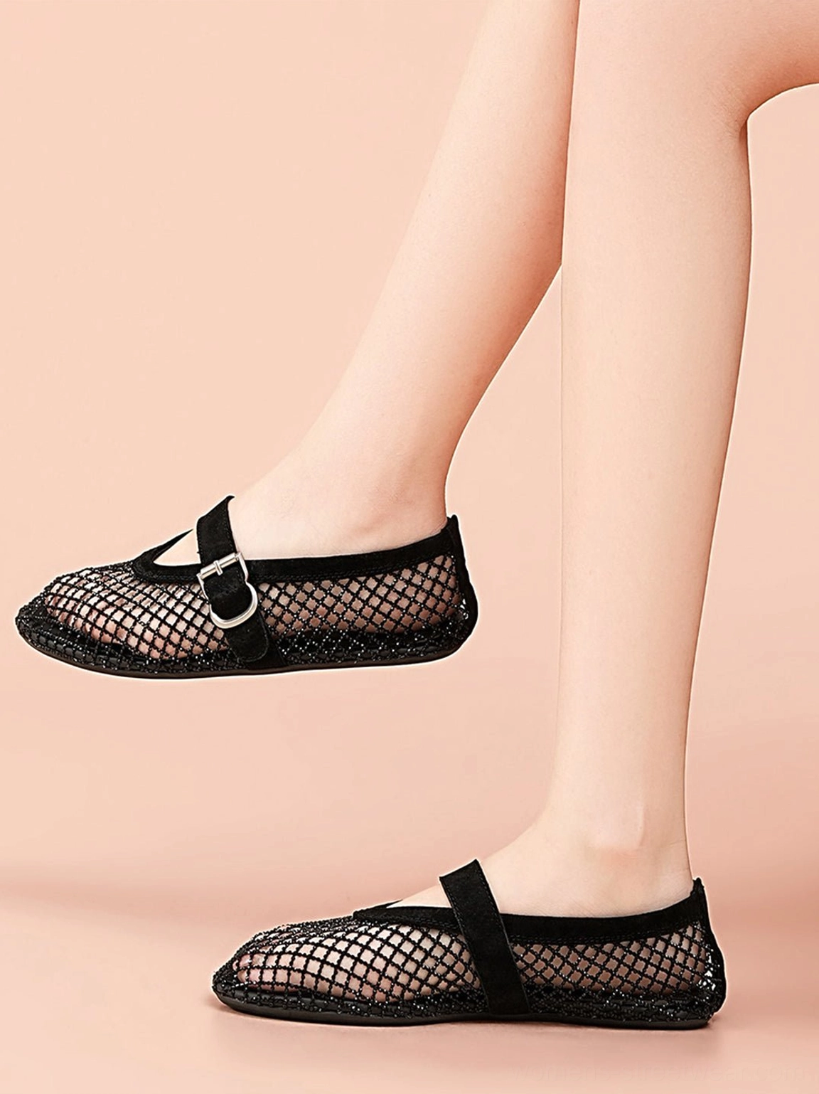 Black woven mesh Mary Jane flats worn on feet, showing the breathable fishnet upper and classic buckle strap