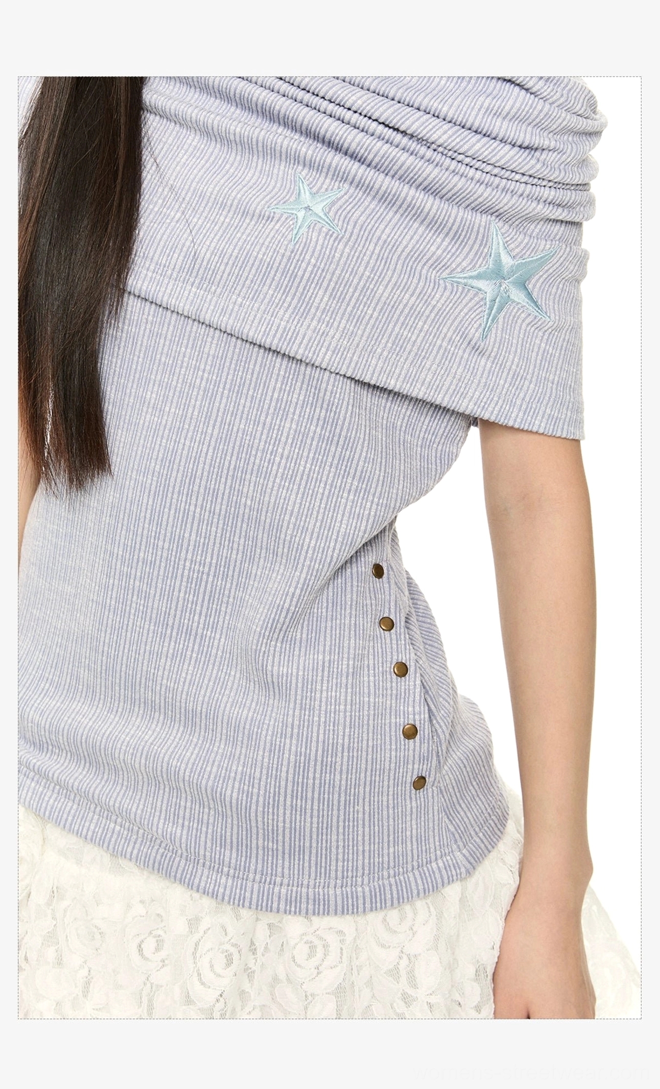 Close-up of blue asymmetric off-shoulder star embroidered pinstripe knit top styled with a white lace skirt