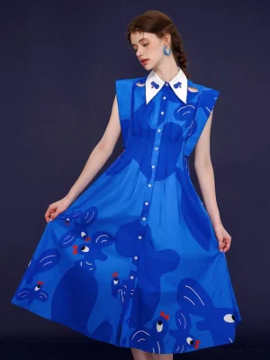 Three-quarter front view of blue bird print midi dress showing the cinched waist, button-down front, white pointed collar, and flowing A-line silhouette