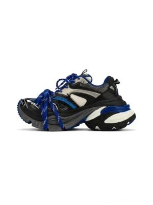 Blue chunky platform dad sneakers with black white and silver color blocking, wrapped blue laces, textured upper, and layered thick rubber sole shown in a three-quarter studio view