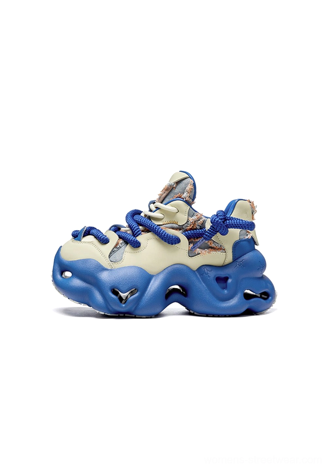 Side three-quarter view of a blue and cream chunky dad sneaker with printed textile upper, thick blue laces, and wavy outsole