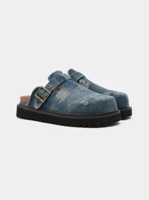 Washed blue distressed denim platform mule clogs with vintage buckle strap, frayed scratch detailing, cork footbed, and chunky anti slip outsole
