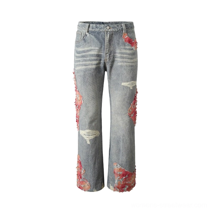 Flat lay front view of blue distressed wide-leg jeans with belt loops, pink frayed side accents, ripped panels, and decorative hem details