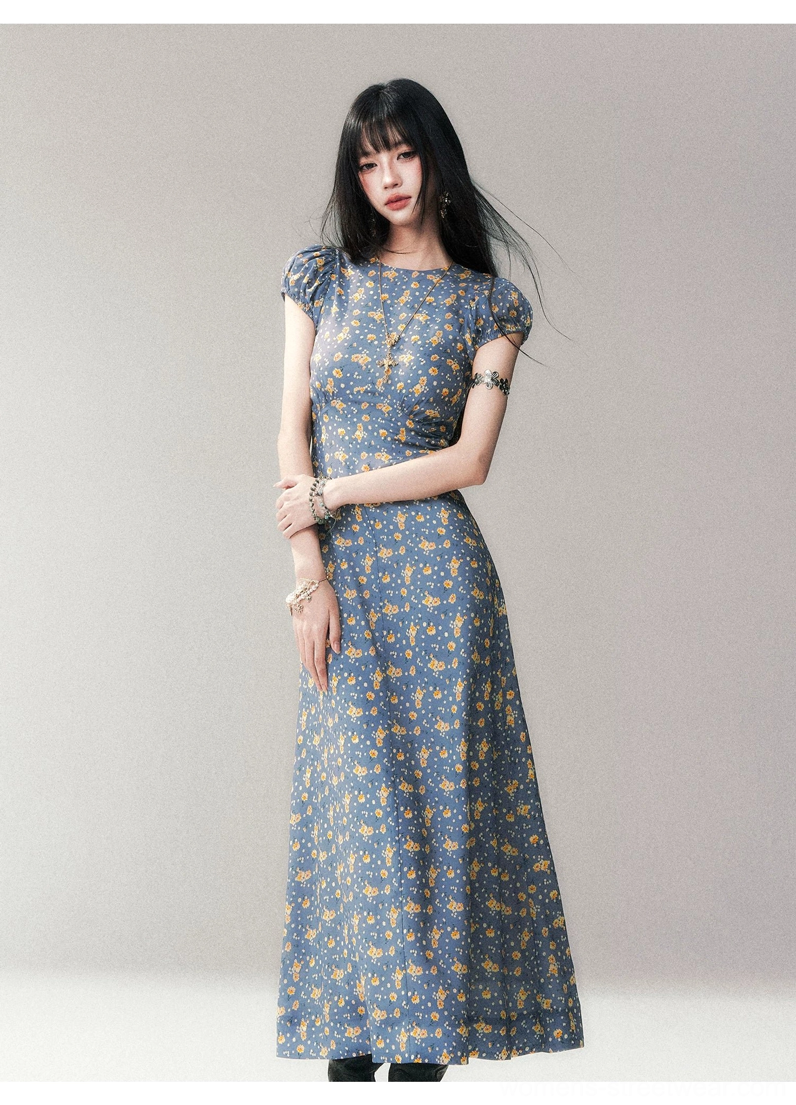 Front full-length studio view of blue ditsy floral open-back maxi dress with puff sleeves and fitted waist