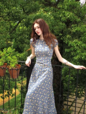 Blue ditsy floral puff sleeve maxi dress with fitted bodice and flowing A-line skirt shown in three-quarter view