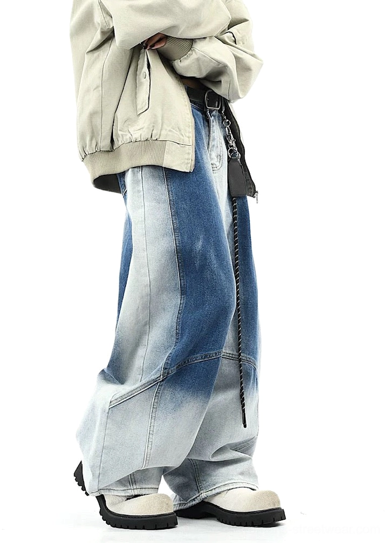 Side view of blue gradient washed wide-leg streetwear pants with draped silhouette, curved side seam details, loose outerwear, and casual sneakers