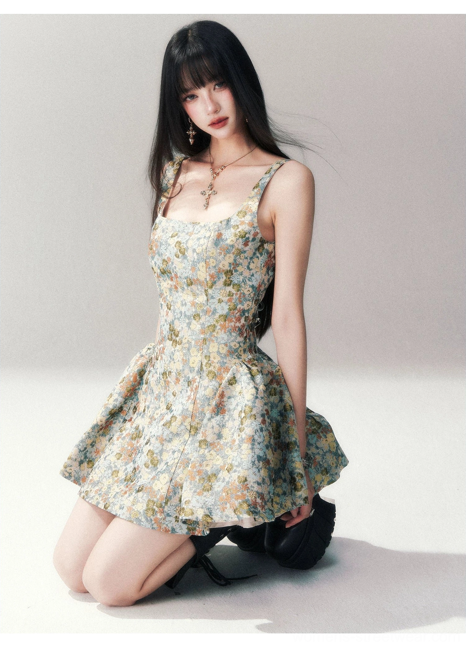 Blue floral brocade mini dress styled with black platform heels and a delicate cross necklace, showing the fitted bodice, square neckline, and flared retro skirt