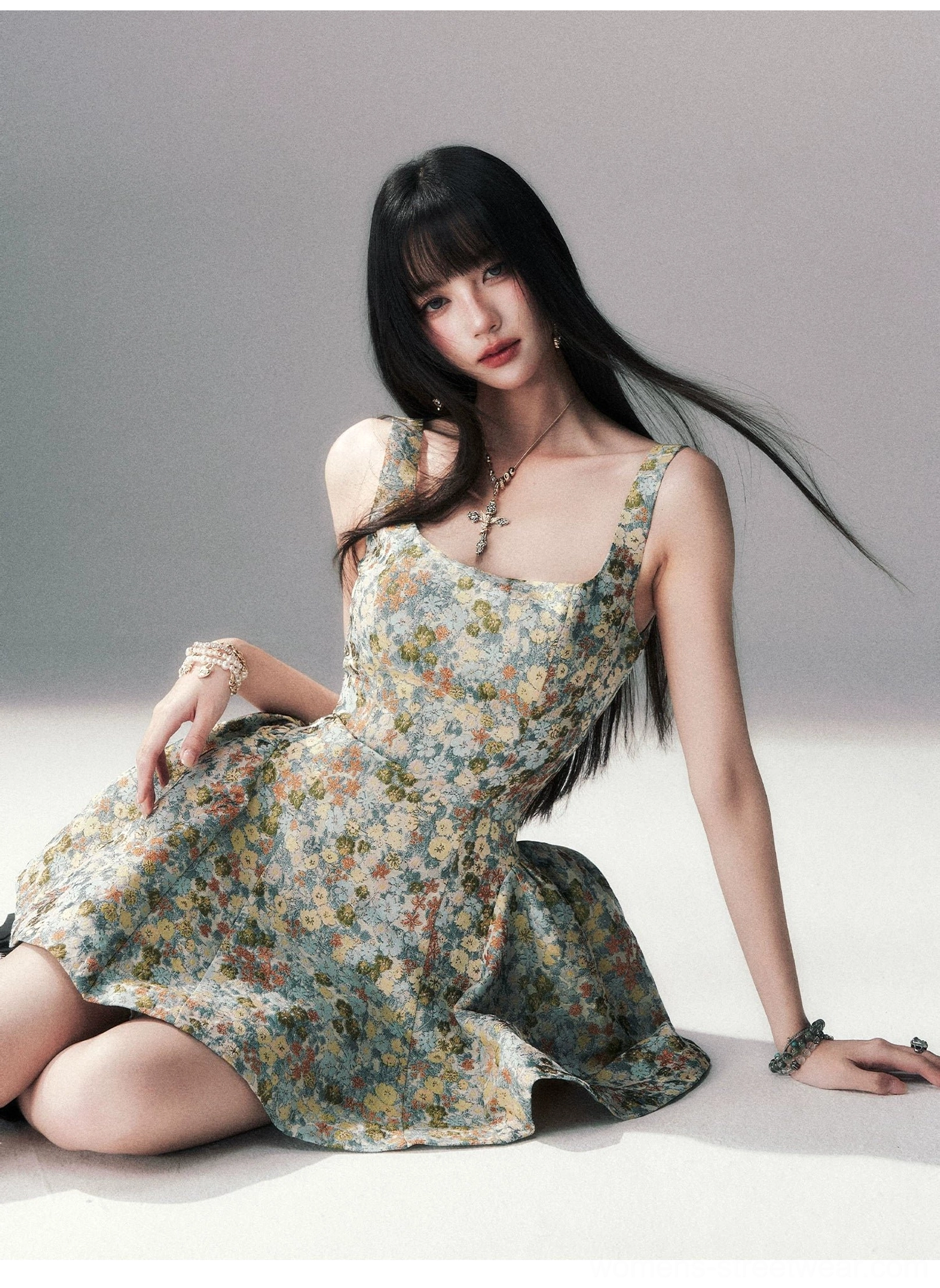 Side seated view of a blue floral brocade mini dress with a voluminous bell-shaped skirt, sleeveless square neckline, and romantic vintage jacquard texture