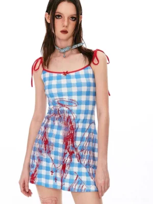 Front view of blue gingham cami mini dress with red neckline trim, tie shoulder straps, and angel wing graphic
