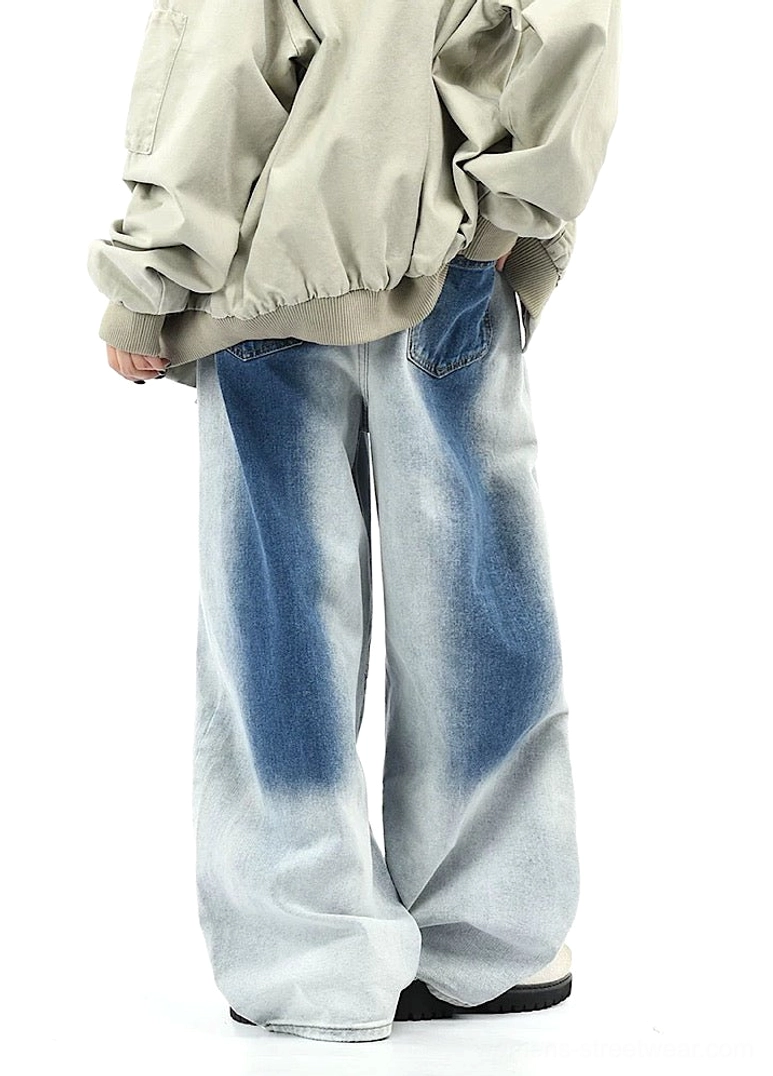Back three-quarter view of blue gradient faded wide-leg streetwear pants with relaxed silhouette, rear denim pockets, cropped top, and loose outerwear