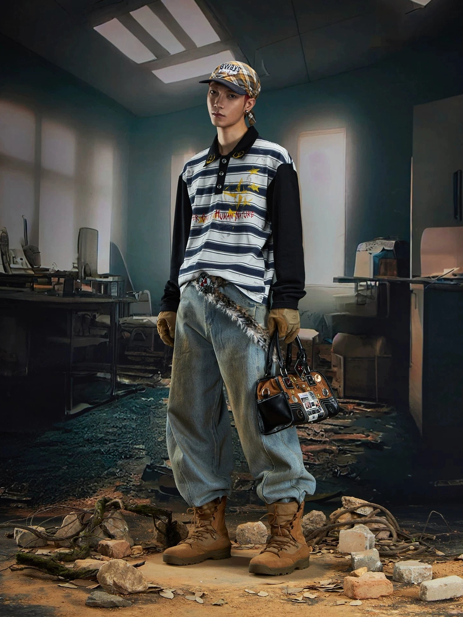 Male model wearing a blue grey striped long sleeve rugby polo shirt with black sleeves, baggy jeans, work boots, and leopard print tote in urban streetwear styling