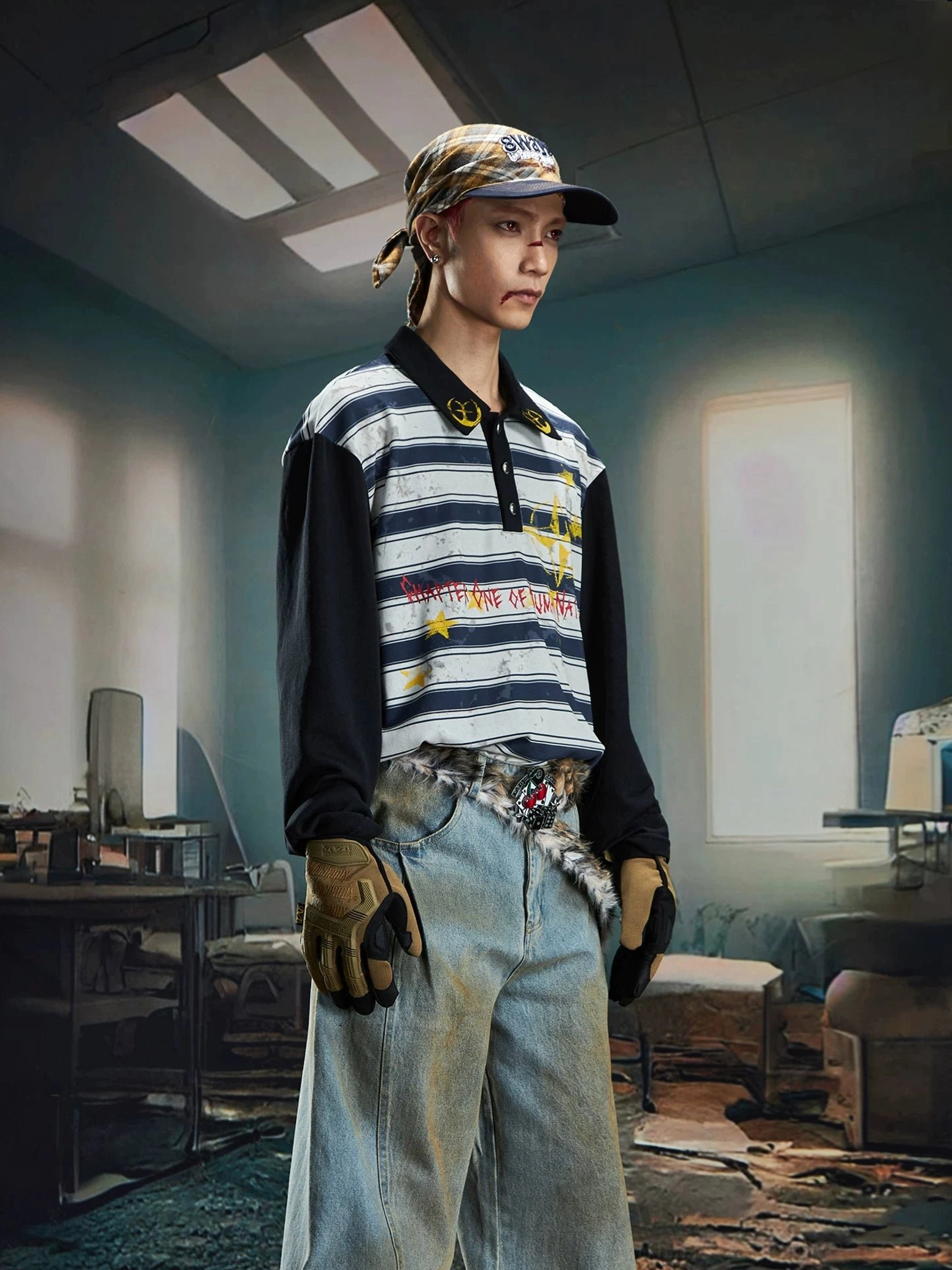 Side three quarter view of a male model in a blue grey striped rugby polo shirt styled with a baseball cap, bandana, gloves, and decorative waist chain