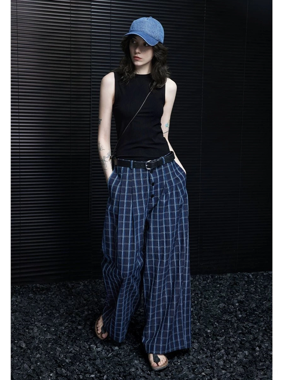 Side view of relaxed blue grid plaid wide-leg streetwear pants with tailored waistband, functional pockets, and loose full-length silhouette
