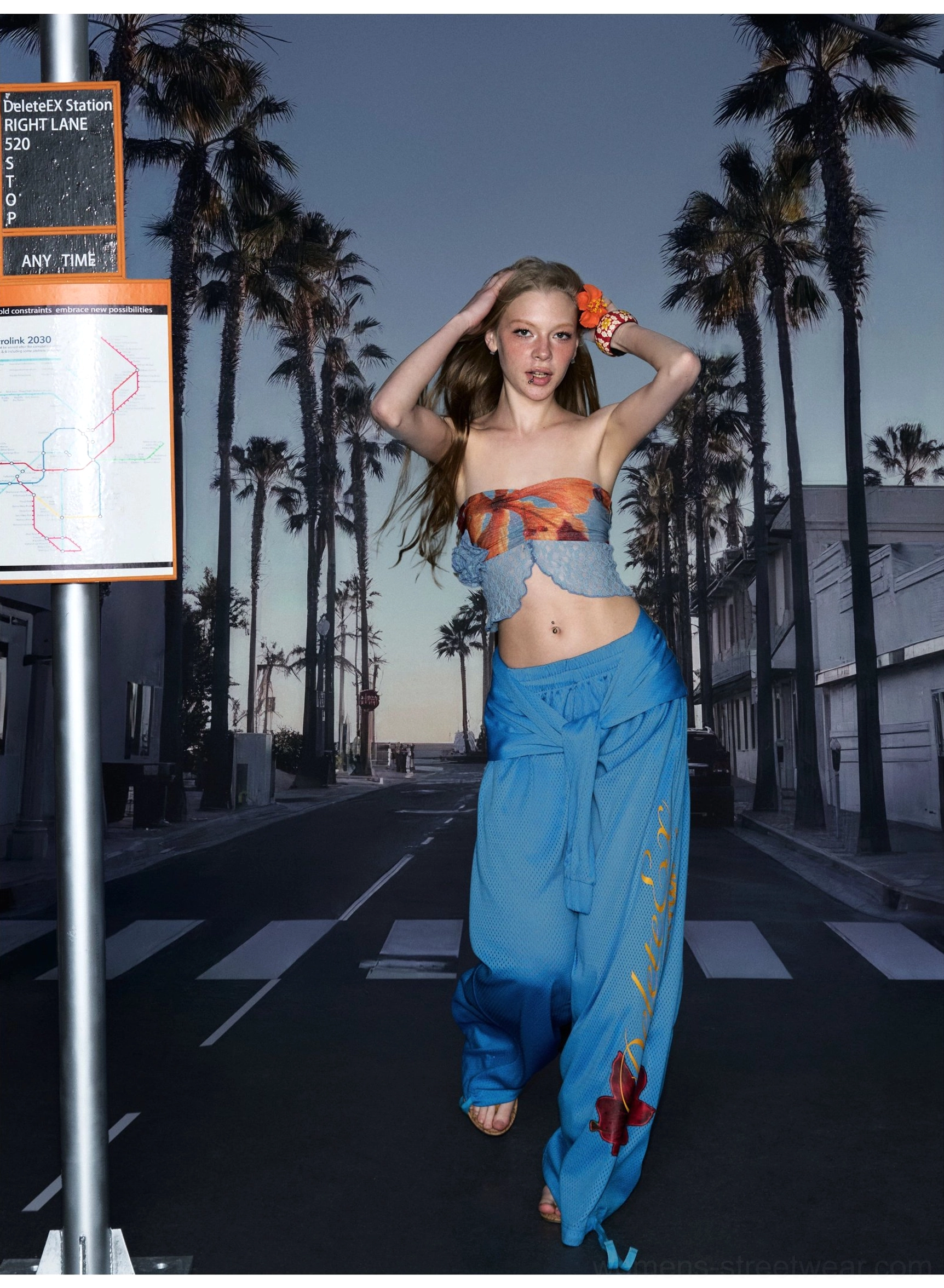Blue hibiscus print wide-leg streetwear pants worn with a cropped top in a tropical outdoor fashion look