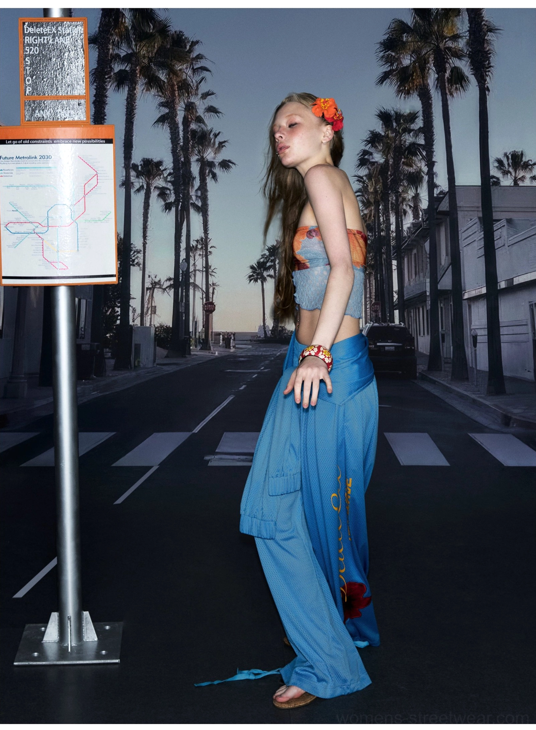 Side profile of blue high-waist wide-leg streetwear pants with tied waistband floral print and script detail